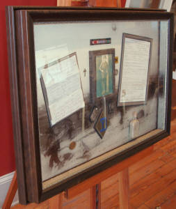 An original letter written from the Battle of Bastogne, Honorable Discharge, dogtag, Chaplain Cross and actual Normandy Beach sand.